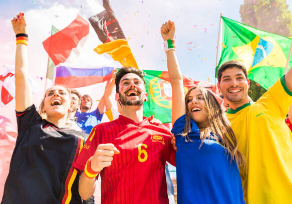 24-75 Happy supporters from different countries together at stadium. Fans from France, Germany, Spain, Brazil and other countries enjoying a match together. Sport, achievement and success concepts
